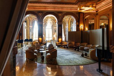 Monte Carlo, Monaco - 01 Kasım 2024: Monaco 'daki Monte Carlo kumarhanesinde lüks bir salon, zarif dekorlar, altın ışıklandırma, lüks koltuklar ve büyük kemerler. Mekan sofistike ve zamansız Avrupa cazibesi yayıyor..