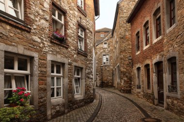 Stolberg, Almanya 'da tarihi taş evlerle dolu büyüleyici bir kaldırım taşı sokağı. Çiçekler pencereleri süslüyor ve fenerler eski dünya atmosferine ekleniyor. Sokaklar davetkar bir şekilde ileride dönüyor..