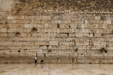 Bir Ortodoks Yahudi, yağmurlu bir kış gününde Kudüs 'teki Batı Duvarı' nda dua eder. Huzurlu ve ruhani bir atmosfer.