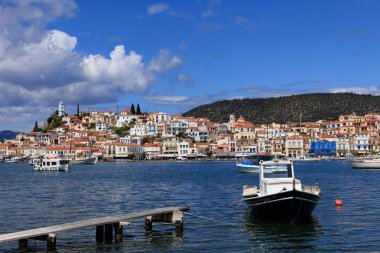 Yunanistan 'ın Poros kenti yakınlarındaki mavi denizde parlak bir gökyüzünün altında yüzen geleneksel balıkçı teknesi. Yunan ada yaşamının mükemmel bir temsili.