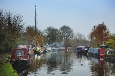 Soğuk ve sisli bir kış sabahı Londra 'da sessiz bir kanal boyunca demirlemiş renkli dar kayıklar ve kanal mavnaları. Bacalardan duman yükselir, ördekler sakin suda yüzer..