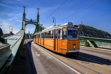 Budapeşte, Macaristan - 9 Eylül 2021: Budapeşte, Macaristan 'daki Liberty Köprüsü' nden geçen ikonik sarı tramvay. Macar başkentinin göbeğinde şehir merkezi ve şehir taşımacılığı.