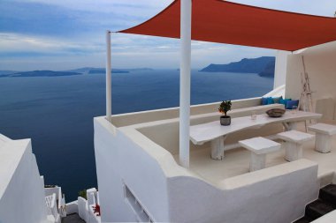 Yunanistan 'ın Santorini kentindeki Ege Denizi manzaralı teras. Beyaz mimari, mavi deniz ve minimalist dekor huzurlu bir Akdeniz atmosferi yaratır.
