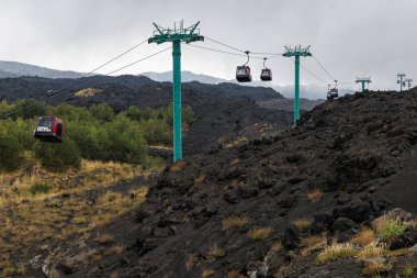 Etna Dağı, Catania, Sicilya, İtalya - 21 Eylül 2025: Sicilya, İtalya 'daki Etna Dağı' nın volkanik yamaçlarından ziyaretçileri taşıyan kablo araçlar. Aktif yanardağ üzerindeki lav alanları, doğa ve turizm manzarası.