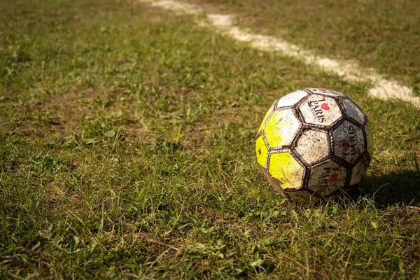 stock image Worn Soccer Ball on Grass Field