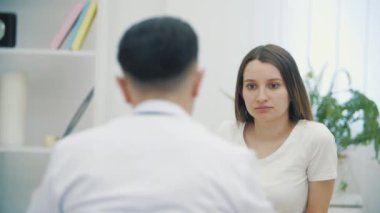 Hamile bir kadının doktorla konuştuğu 4K yavaş çekim videosu. Doktoru ziyaret etme kavramı.