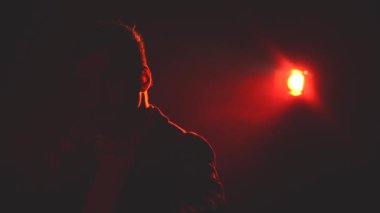 4k slow motion video of man screaming on dark background with blue and pink lights. Concept of man screaming.