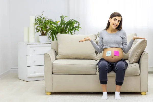 将来の赤ちゃんの性別を意味する胃の上にピンクと青の紙で肯定的な妊婦の写真 妊婦の概念 — ストック写真