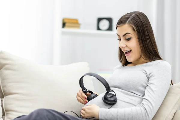 Photo of pregnant woman with headphones. Concept of pregnant woman.