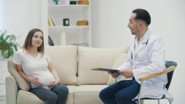 Hamile bir kadının doktorla olan randevusunun 4k yavaş videosu. Tıbbi danışmanlık kavramı.