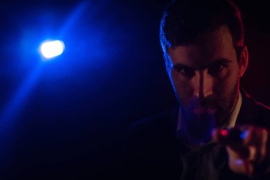 Ayakta duran adamın fotoğrafı ve arka planda pembe ışık. Takım elbiseli adam kavramı.