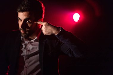 Ayakta duran adamın fotoğrafı ve arka planda pembe ışık. Takım elbiseli adam kavramı.