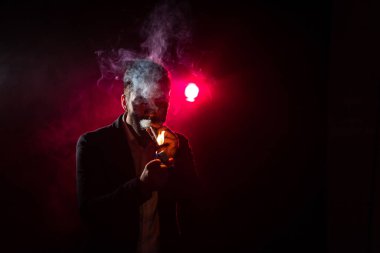 Pembe arka planda sigara içen adamın fotoğrafı. Sigara içme kavramı.