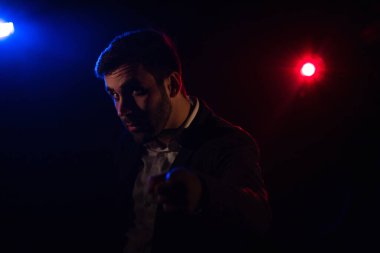 Ayakta duran adamın fotoğrafı ve arka planda pembe ışık. Takım elbiseli adam kavramı.