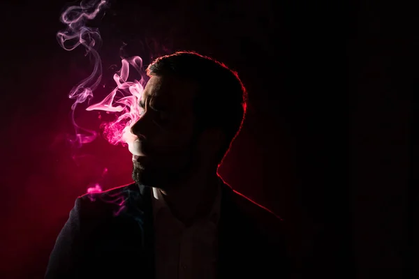Photo of smoking man on pink background. Concept of smoking.