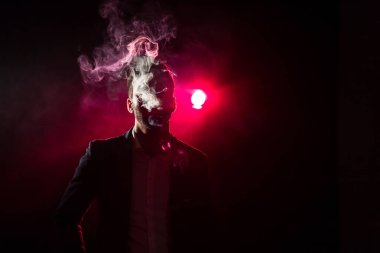 Pembe arka planda sigara içen adamın fotoğrafı. Sigara içme kavramı.