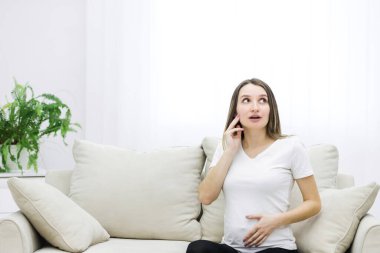 Cropped photo of pregnant woman looking somewhere. Concept of pregnant woman.