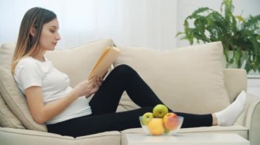 4k slowmotion video of pregnant woman with apple reading a book. Concept of pregnant woman.