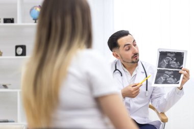 Hamile bir kadının doktorla konuştuğu fotoğraf. Doktoru ziyaret etme kavramı.