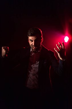 Pembe arka planda takım elbiseli duygusal bir adamın fotoğrafı. İnsan duruşu kavramı.