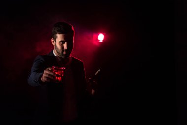 Ayakta duran adamın fotoğrafı ve arka planda pembe ışık. Takım elbiseli adam kavramı.