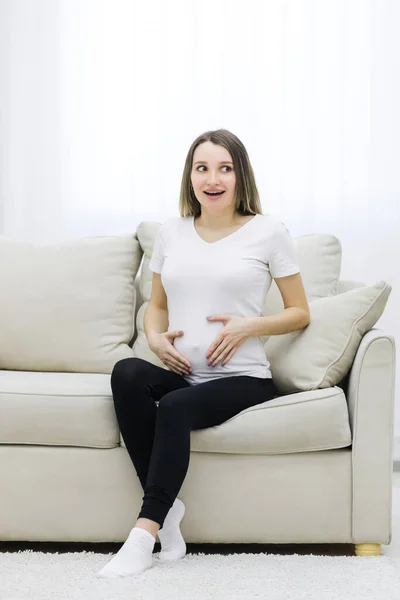 Cute woman looking on the right in the living room. Concept of pregnant woman.