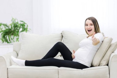 Smilling pregnant woman showing thumb up. Concept of pregnant woman.