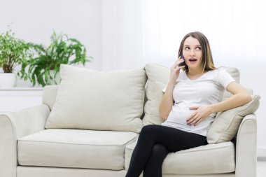 Photo of pregnant woman talking over the phone. Concept of pregnant woman.