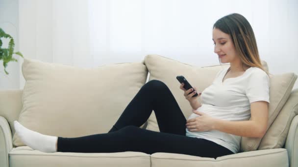 Slowmotion Video Pregnant Woman Sitting White Sofa Phone Concept Pregnant — Wideo stockowe