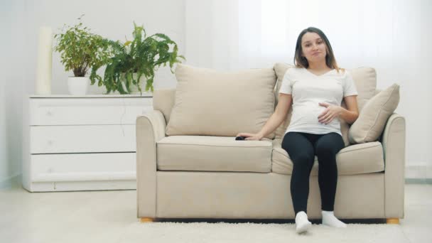 Вялое Видео Беременной Женщины Сидящей Белом Диване Концепция Беременной Женщины — стоковое видео