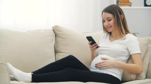 妊娠中の女が笑顔でメールするスローモーション動画 妊婦の概念 — ストック動画