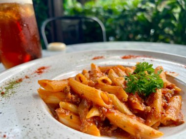 Spagetti domates sosu ve plaka üzerinde fesleğen ile