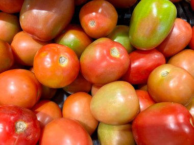 Domatesler markette. Taze domateslerle dolu bir fotoğraf yığını. Geleneksel pazarda satılmaya hazır olgun kırmızı domatesler.