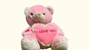 Kırmızı kalbi olan oyuncak ayı beyaz arka planda izole edilmiş.