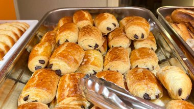 Otelde kahvaltı için çeşitli ekmekler var. Otel misafirleri için kahvaltı büfesi. Sütlü ekmek, baget ve beyaz ekmek gibi bir sürü ekmek.