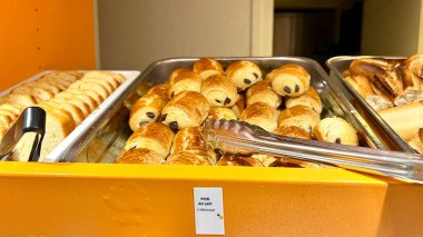 Otelde kahvaltı için çeşitli ekmekler var. Otel misafirleri için kahvaltı büfesi. Sütlü ekmek, baget ve beyaz ekmek gibi bir sürü ekmek.