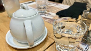 Paris, Fransız. 19 Kasım 2024. Soğuk bir kış günü restoranda vücudunu ısıtmak için sıcak suyla dolu beyaz çay demliği.