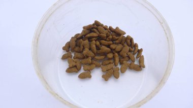 Beyaz arka plan üzerine şeffaf bir kavanoz içine konmuş kedi maması yığını