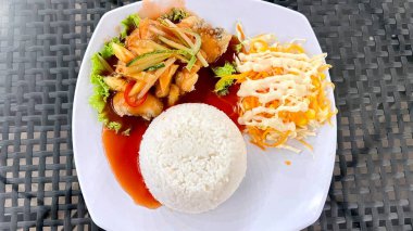 Beyaz tabakta pirinç ve sebzeli canlı tatlı ve ekşi gourami balığı, taze taze ve yemek blogcusu için uygun balık eti sergileniyor. Üst Görünüm, Kapat