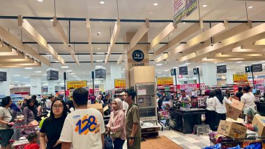 Bogor, 1 Mart 2025. Kalabalık bir süpermarkette canlı bir sahne. Çeşitli alışveriş merkezleri, alışveriş arabaları ve reklam tabelalarıyla dolu. Perakende ve alışveriş kültürü temaları için mükemmel.