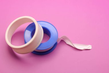 Thread seal tape (plumber's tape) isolated on purple background clipart