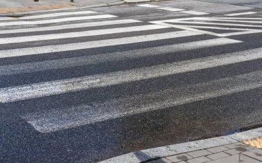 Güneşli havada, ıslak asfaltta yaya geçidi