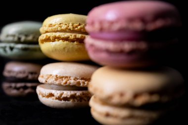 İki sıra halinde koyu arkaplan üzerinde Fransız renginde kurabiyeler.