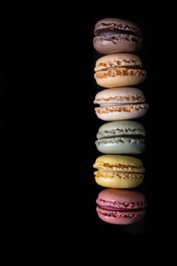 Fransız renkli badem kurabiyeleri, arka planda en üstteki sıraya dizilmişler. Duvar kağıtları ve arka planlar için. Makaronlar