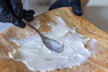 Pita ekmeğine krem peynir sürüyorum..