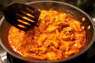 Tavada domates ezmesi içinde yakın plan et kızartması. Kızartma tavasında kızartılmış lezzetli et parçaları..