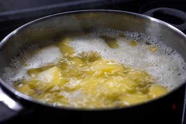 Sıcak bir tencerede haşlanmış patates. Üst Manzara. Kaynar su