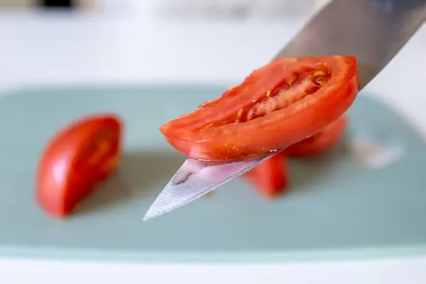 stock image A chef slices tomatoes on a cutting board while standing in the kitchen. Close-up of a tomato slice