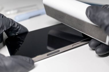 Mikrofiberle telefon ekranını silerken. Telefondaki toz ve pislik. Telefonu temizliyorum.