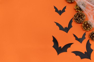 Cadılar Bayramı geçmişi - parlak turuncu arka planda siyah yarasalar ve örümcek ağları. Cadılar Bayramı atmosferi.